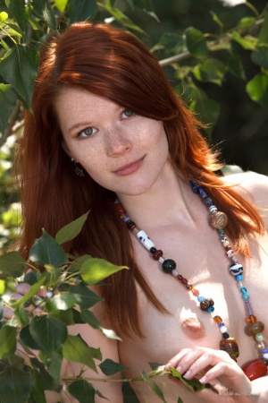 Hot redhead Mia Sollis frees her teen body from a swimsuit in a brook