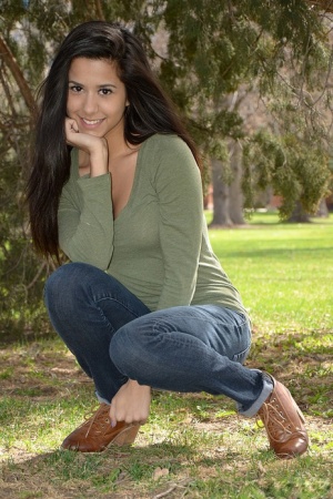 Latina chick Bella Quinn climbs a tree in the park wearing a sweater and jeans
