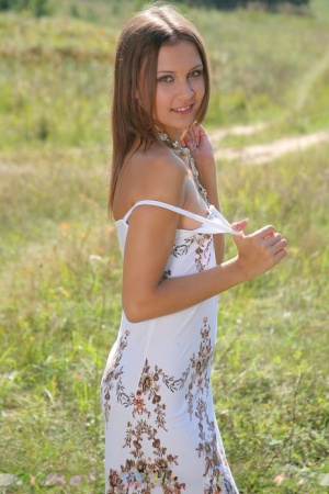 Petite white girl Rita B models naked in a farmers field