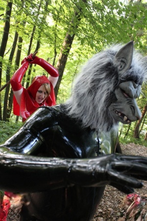 Cosplay enthusiasts don latex Little Red Riding Hood and Big Bad Wolf costumes