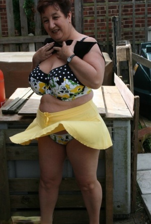 Thick older woman Kinky Carol models a bikini on patio stones