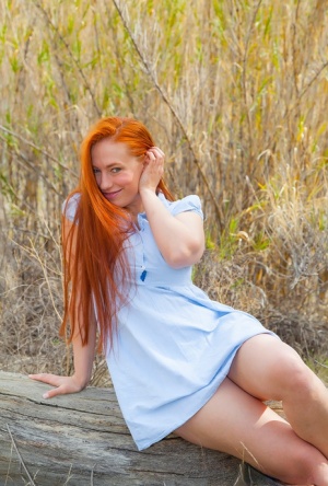 Beautiful redhead Titania strips naked outdoors to catch some rays on her tits 75018489