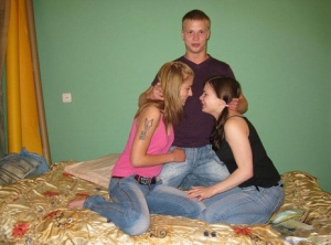 Teen girls and their guy friend remove faded jeans before a threesome on a bed 80767745