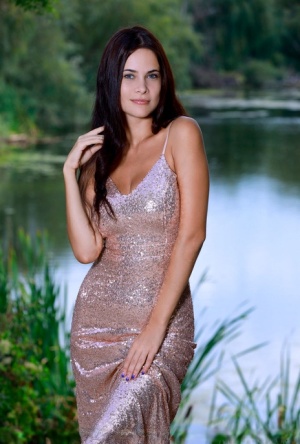 Dark haired teen Martina Mink slips off a long dress to pose nude by a lake 32494503