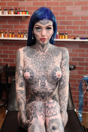 Heavily tattooed girl Amber Luke poses naked in a tattoo shop