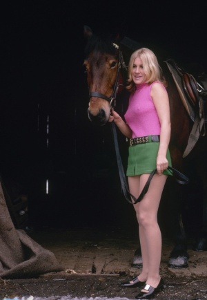 Blonde female reveals thigh and ass while mounting her horse in a short skirt 47856885