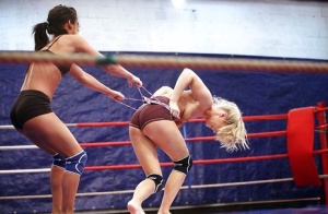 Sporty lesbians punching and grasping each other in the ring
