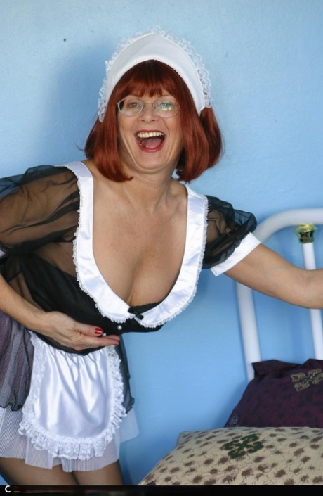 Mature redhead Miss Abigail exposes her underwear while wearing a maid uniform
