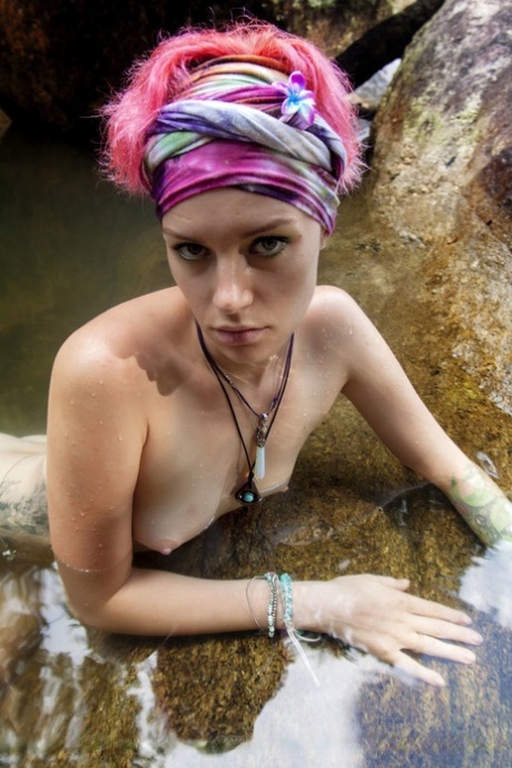 Teen girl with dyed hair Leocadia gets totally naked in a pool below waterfall 83316338