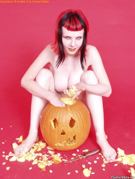 Redheaded goth Szandora pulls the guts out of a pumpkin in the buff 45484425