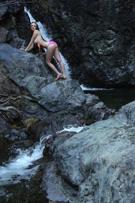 Caucasian girl Lily Xo takes off her bikini top in front of a waterfall 54292001