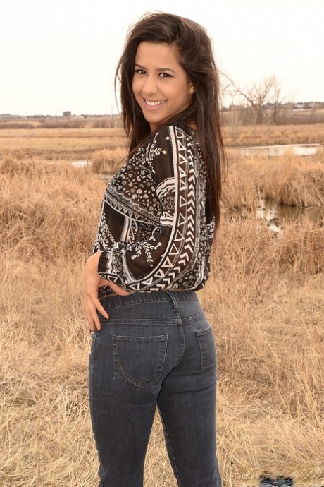 Latina girl Bella Quinn models in a field wearing a bra and jeans 80385557