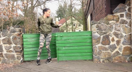 Brunette chick Dellai pulls down camo pants for a badly needed pee in public