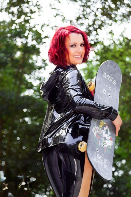 Redheaded model Lara Larsen unzips her latex clothing at a skate park 11349708