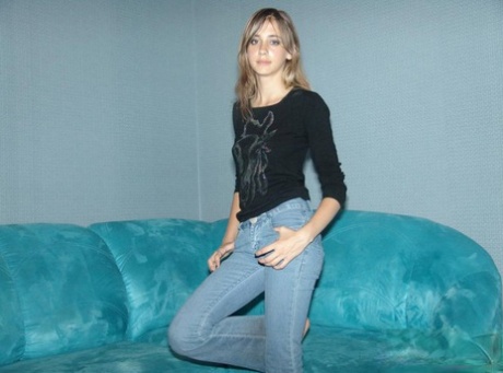 Amateur solo girl in bare feet and jeans starts to remove her sweater