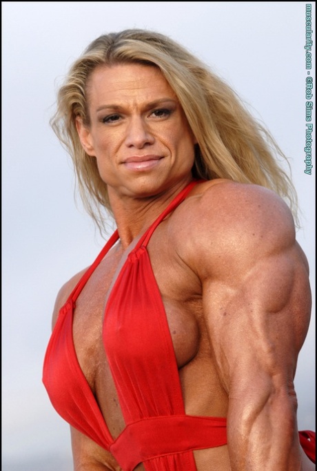 Female bodybuilder Tina Chandler models red swimwear on a beach 64248782
