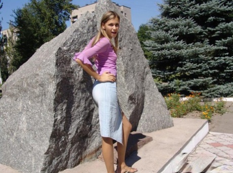 Blonde amateur hitches up her long denim skirt in a public square 56134862