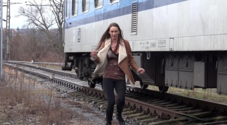 Cynthia Vellons pulls down black tights for a quick piss near railway cars 52536566