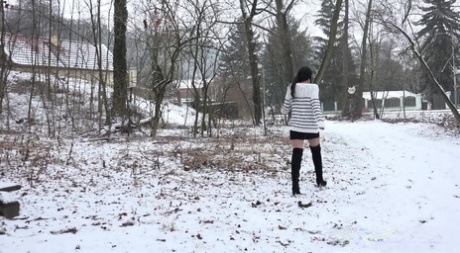 Pretty dark haired babe pisses outside in the snow