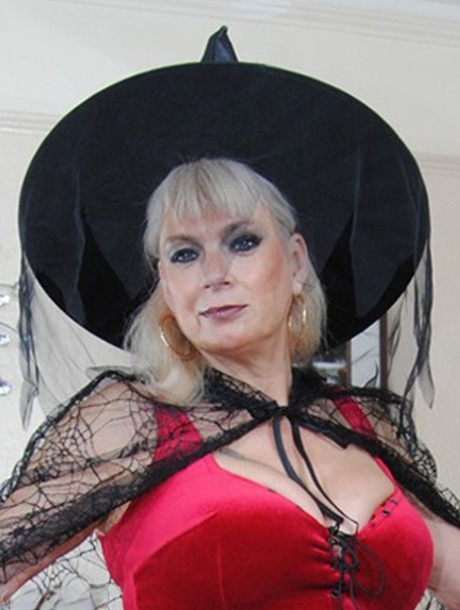 Middle-aged platinum blonde Dimonty models lingerie and a witch's hat 80726065