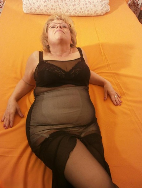 Tipsy hot granny Caro spreading legs on the bed wearing black stockings 84545003