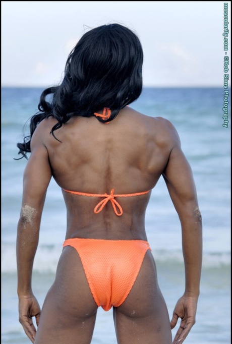 Ebony bodybuilder Debra Dunn poses at the ocean in a string bikini 92437490