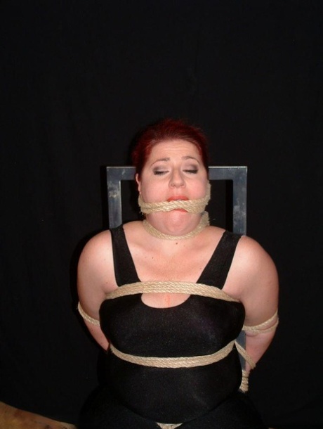 Overweight redhead is threatened with a knife while tied to a chair 65250070