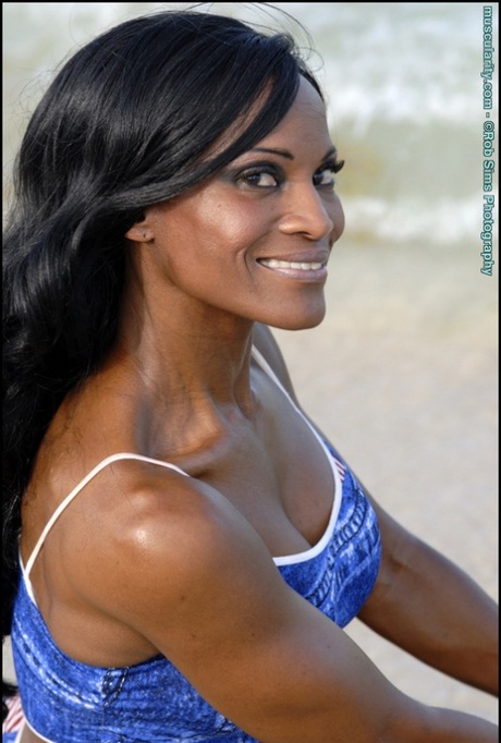 Black bodybuilder Debra Dunn flexes her muscles at the beach in denim attire 53183787