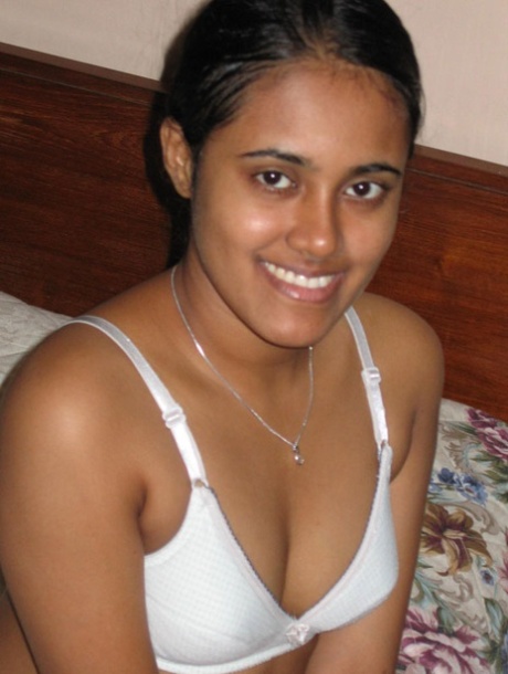 Indian girl with a nice smile shows her breasts on top of a bed 22479602