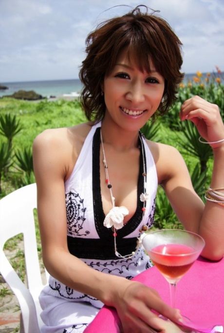 Pretty Japanese woman displays her cleavage over a cocktail near the ocean 29765318