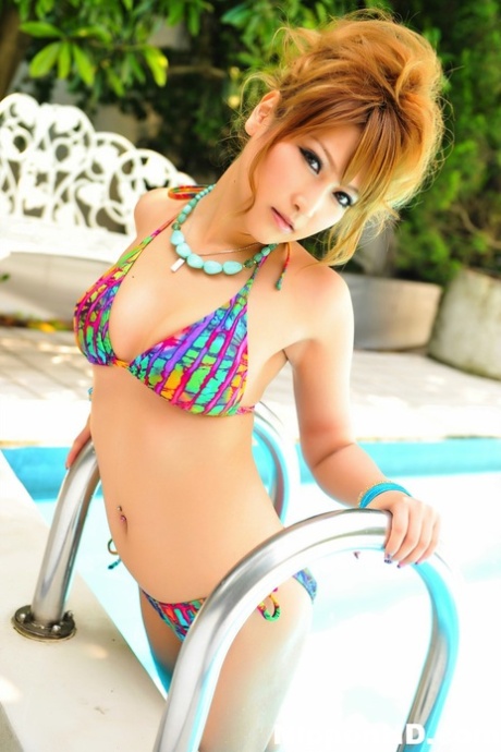 Gorgeous Japanese redhead models a bikini next to a swimming pool 64738462