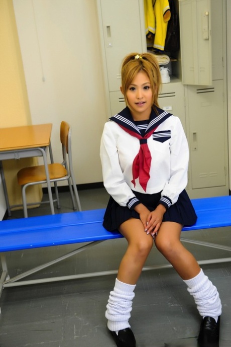 Adorable Japanese student with a pretty face poses on a bench in her uniform 65546820