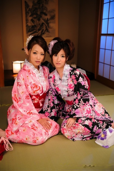 A pair of Japanese Geishas model together in their brightly colored kimonos 73957652