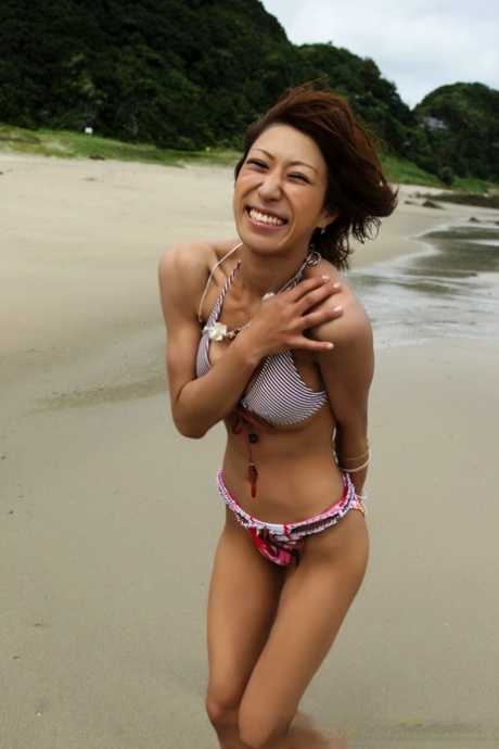 Japanese girl wears a bikini while playing in the ocean during a beach holiday 82434999