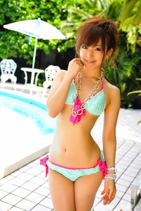 Adorable Japanese girl models a pretty bikini on a poolside patio 83484184