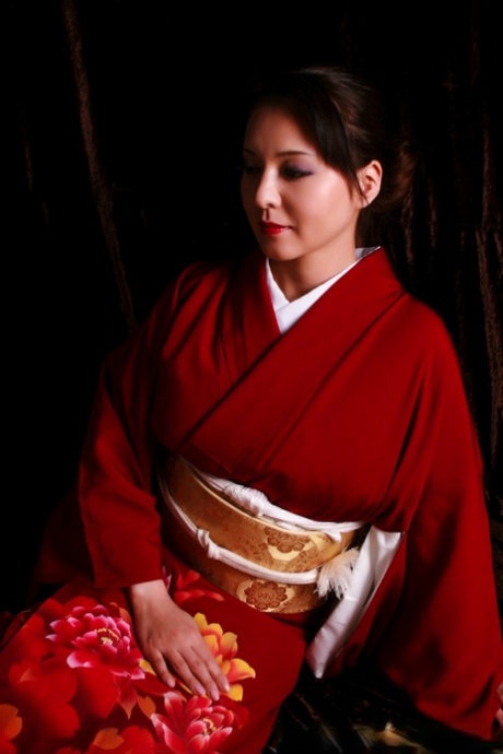Japanese woman sports red lips while producing a knife in traditional clothing 89324898