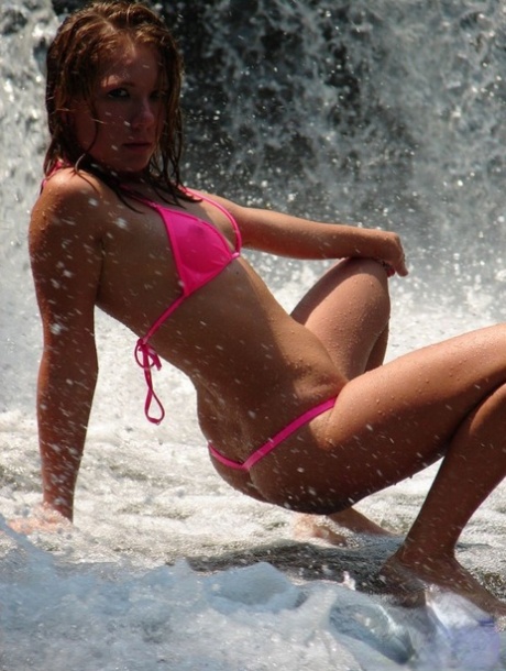 Teen solo girl Leia models a pink bikini underneath a waterfall 91053131