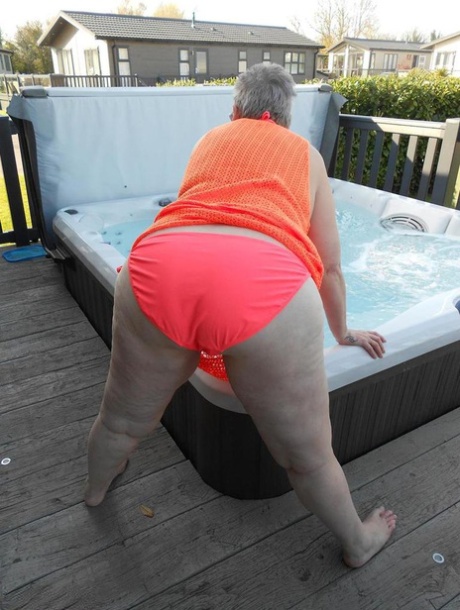 Fat nan bares her boobs while in a patio hot tub before getting naked on a bed 77365441