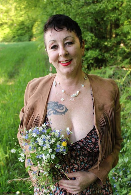 Older woman Mary Bitch picks a bunch of flowers while getting naked in a field 11143273