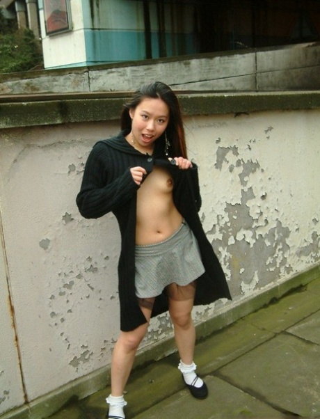 Asian girl gets naked in a skirt on a sidewalk in the United Kingdom 55026250