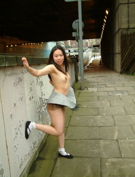 Asian girl gets naked in a skirt on a sidewalk in the United Kingdom 55026250