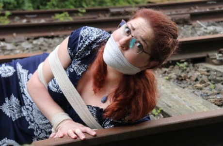 Fully clothed redhead is left gagged and bound on railway tracks 75694534