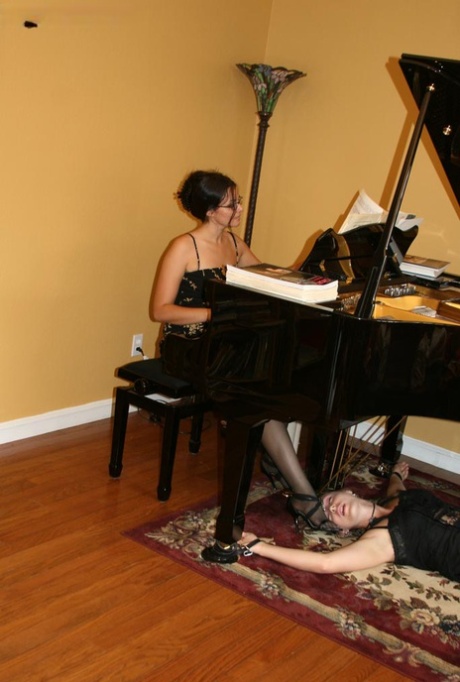 Brunette pianist plays while a restrained woman licks her heels 36061228