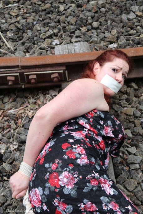 Natural redhead is left hog tied and gagged on railway tracks 97474102