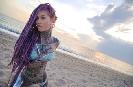 Heavily tattooed girl releases tiny tits from bikini top on a sandy beach 99907499