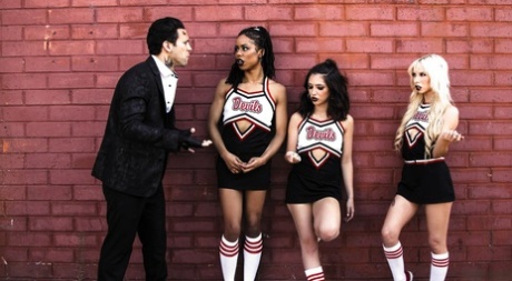 Three cheerleaders partake in a reverse gangbang with a tattooed man