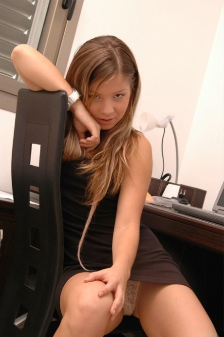 Charming young girl uncovers her perky titties at her computer desk 34832432
