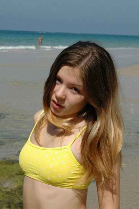 Charming 18 year old models a yellow bikini while at the beach 44417251