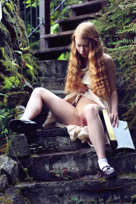 Young redhead Dolly Little exposes herself on garden steps while reading 50970658