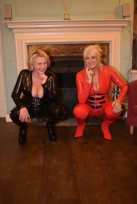 Mature lesbians get together in head-to-toe latex attire on a loveseat 20851976